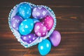 Blue Basket in the form of heart with Easter eggs. Brown wooden Royalty Free Stock Photo