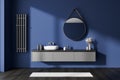 Blue bathroom interior with sink and mirror, accessories on drawer