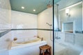 Blue bathroom interior with white tile trim wall, glass cabin shower and bath tub. Royalty Free Stock Photo