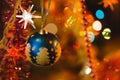 Blue bauble in Christmas tree surrounded by colourful lights Royalty Free Stock Photo