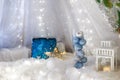 Blue baubles in glass vase. Christmas tree toys and New Year decorations. Unfocused white background with shiny sparkling garland Royalty Free Stock Photo