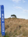 Blue beach access post in sand dunes