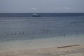 Blue beach at day time with fish farm with cages for fish and shrimp in Bali.