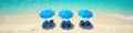 Blue beach umbrellas and chairs forming a triangle on sand, beach, pattern Royalty Free Stock Photo