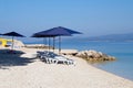 Blue beach umbrellas and chaise for relax and comfort on sea resort. Summer vacations and travel for seaside. Paid service on