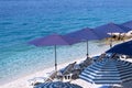 Blue beach umbrellas and chaise for relax on sea resort. Summer vacations and travel for seaside. Paid service on comfort beaches