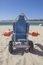 Blue beach wheelchair on sand ready to use Royalty Free Stock Photo