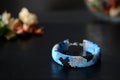 Blue beaded bracelet camouflage coloring on a dark background Royalty Free Stock Photo