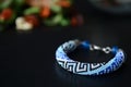 Blue beaded bracelet with greek ornament on a dark background Royalty Free Stock Photo