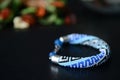 Blue beaded bracelet with greek ornament on a dark background Royalty Free Stock Photo