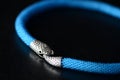 Blue beaded necklace with snake head lock on a dark background