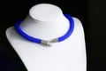 Blue beaded necklace with snake head lock on a dark background