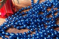 Blue beads with red christmas bell on old wood background Royalty Free Stock Photo