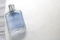 Blue beautiful glass transparent fashionable glamorous bottle of cologne, perfume and ribbon of sparkling rhinestones, diamonds an Royalty Free Stock Photo