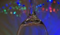 In blue Beautiful wine glass upside down on blue tones on a luminous christmas lights bokeh background Royalty Free Stock Photo