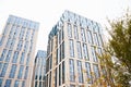 Blue beige modern apartment building, tree. Tile and glass facade. View from street, view from below. Astana Nur-Sultan,