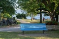 Blue bench in public park with lake in the background Royalty Free Stock Photo