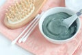 Blue bentonite clay in a bowl, wooden hairbrush and cotton swabs. Diy facial mask and body wrap recipe. Natural beauty treatment