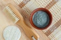 Blue bentonite clay powder in the bowl and wooden body brush. Clay texture close up. Diy mask and body wrap recipe. Natural beauty