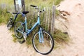 Bicycle built for two leaning on fence by beach and dunes Royalty Free Stock Photo