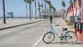 Bicycle cruiser bike by ocean beach, California coast USA. Summer cycle, lifeguard hut and palm tree Royalty Free Stock Photo