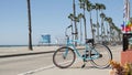 Bicycle cruiser bike by ocean beach, California coast USA. Summer cycle, lifeguard hut and palm tree Royalty Free Stock Photo