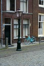 A blue bicycle is standing on a Dutch street. Old classic holland street with a blue bike Royalty Free Stock Photo