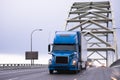 Blue big rig semi truck transporting semi trailer on arched Fremont bridge Royalty Free Stock Photo