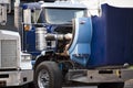 Blue big rig semi truck with open hood standing on the parking lot for repair engine and service work Royalty Free Stock Photo