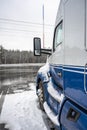 Blue big rig semi truck tractor high cab with truck driver rest compartment standing for truck driver rest on the industrial truck Royalty Free Stock Photo