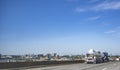 Blue big rig semi truck transporting liquid cargo in tank semi trailer running on the overpass highway road with city of Portland Royalty Free Stock Photo