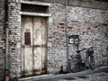 Blue bike against an old painted white brick wall and door Royalty Free Stock Photo