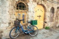 Blue bike with green basket against rustic building Jaffa, Israel