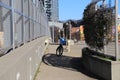 A blue bike parked on a sidewalk on a freeway overpass surrounded by office buildings and blue sky