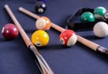 Blue billiard table with balls and cue.