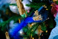 Blue bird with sparkles on a branch of a Christmas tree and a blurred dark background with colorful bokeh. Soft focus Royalty Free Stock Photo