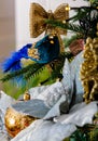 Blue bird with sparkles and gray poinsettia flower on a branch of a Christmas tree and a blurred background. Soft focus. Royalty Free Stock Photo