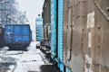 Blue and black railway cars stand on a railway siding in winter, the snow is everywhere