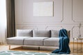 Blue blanket on grey couch in elegant living room interior Royalty Free Stock Photo