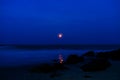 small blood lunar in the dark blue night at the sea