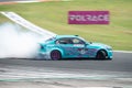 Blue BMW E90 Series 3 producing smoke on a trail for a drift competition