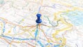 A blue board pin stuck in Udine on a map of Italy