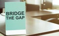 Blue board with text Bridge The Gap on the office background Royalty Free Stock Photo