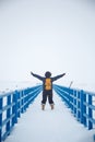 Blue boardwalk with woman arms outstretched on snowy day Royalty Free Stock Photo