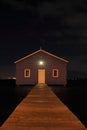 Blue boat house on river at night