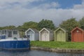 Blue boat moored next to some different coloured huts Royalty Free Stock Photo