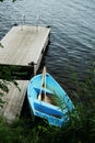 Blue boat with oars at the old wooden pier Royalty Free Stock Photo