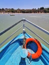 A blue boat sailing in the bay sea towards the beach. Inside View from the front of the boat.