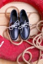 Blue boat shoes on wooden background near red lifebuoy and rope Royalty Free Stock Photo