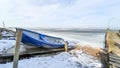 Blue boat on the shore of the frozen sea Royalty Free Stock Photo